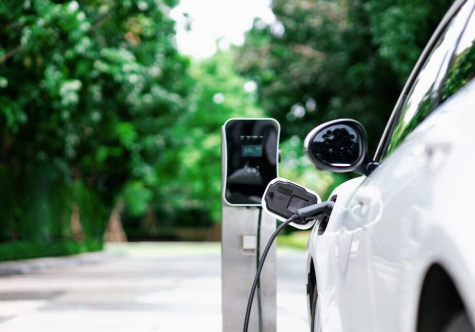 White electric car charging outdoors.
